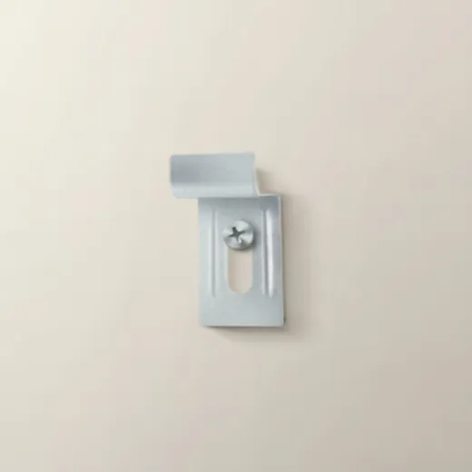 De muurhaak met één schroef aan de muur, het gebogen lipje naar boven en van de muur af